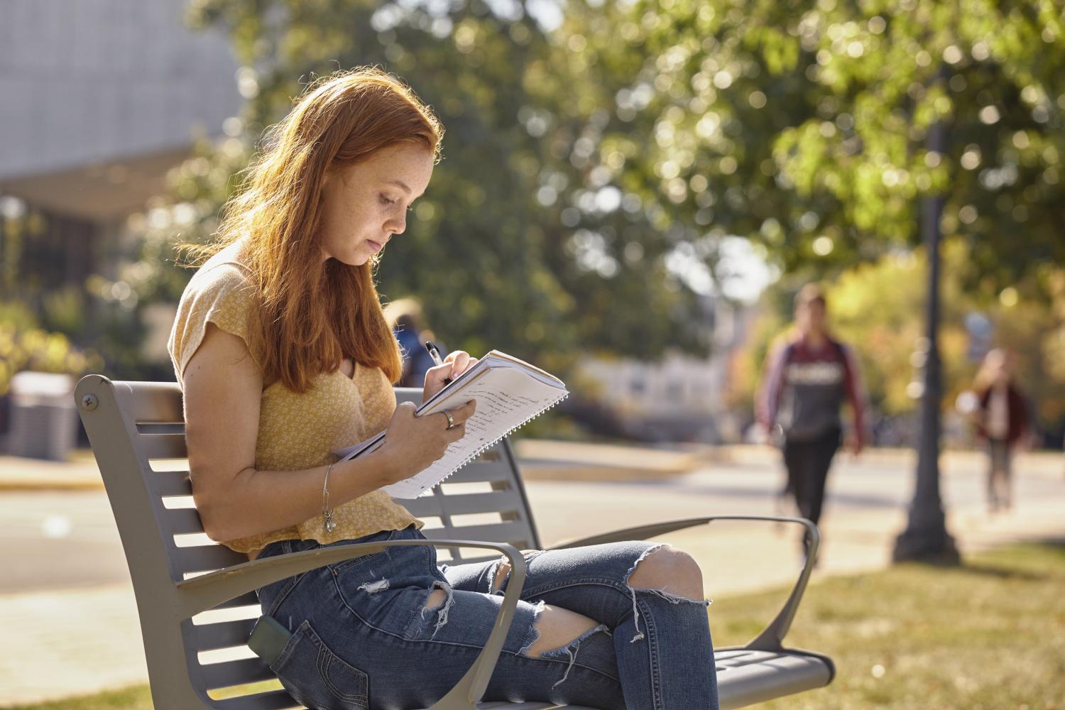 一位<a href='http://uppb.ngskmc-eis.net'>全球十大赌钱排行app</a>学院的学生在校园里的长椅上读书.